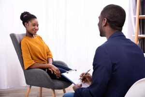 woman in yellow shirt talks with therapist about what superior behavioral health treats